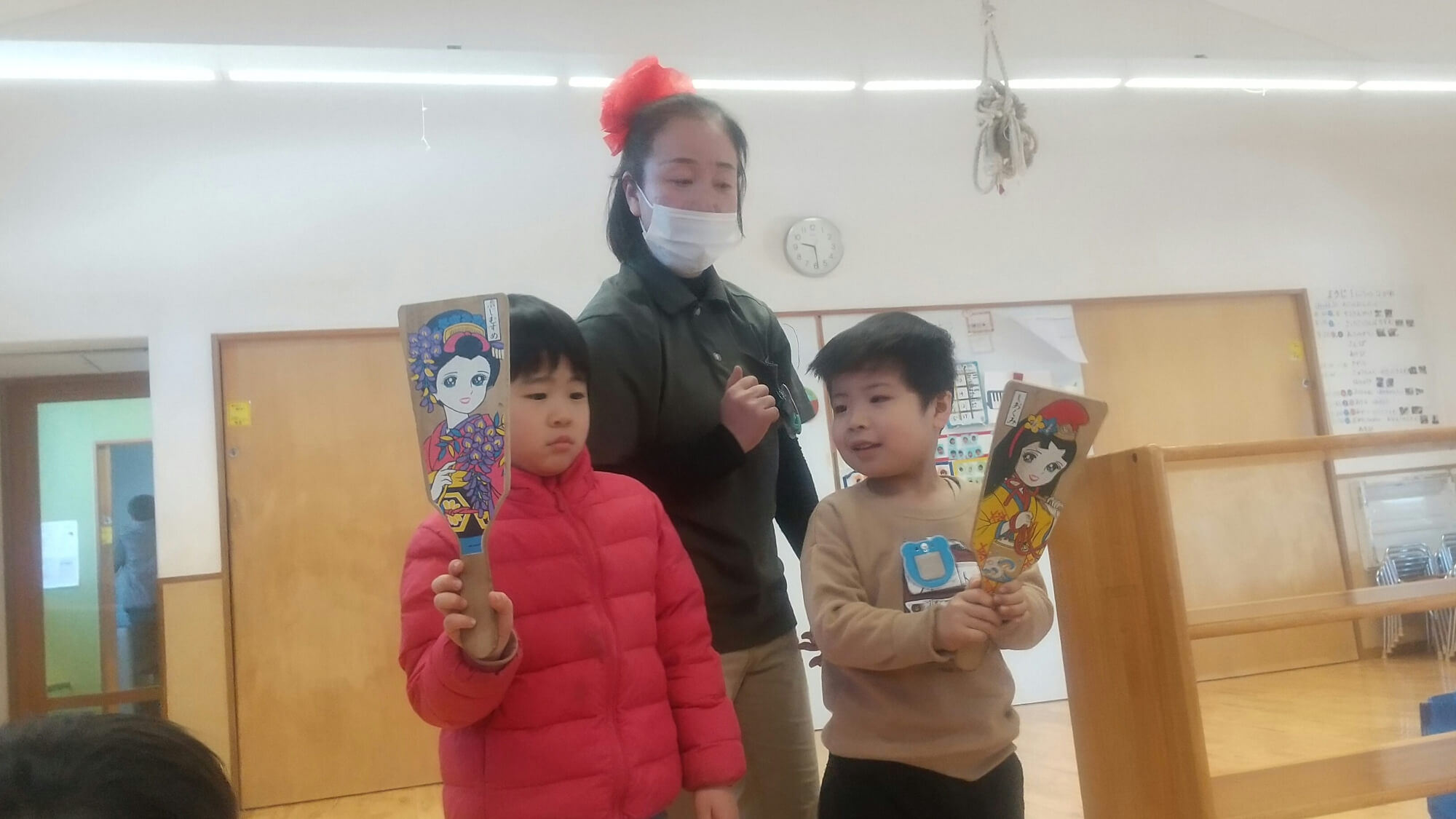 羽子板を持つ子どもたち