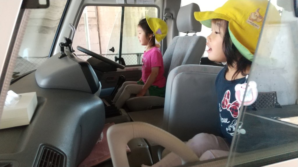バスの運転席に座る子どもたち