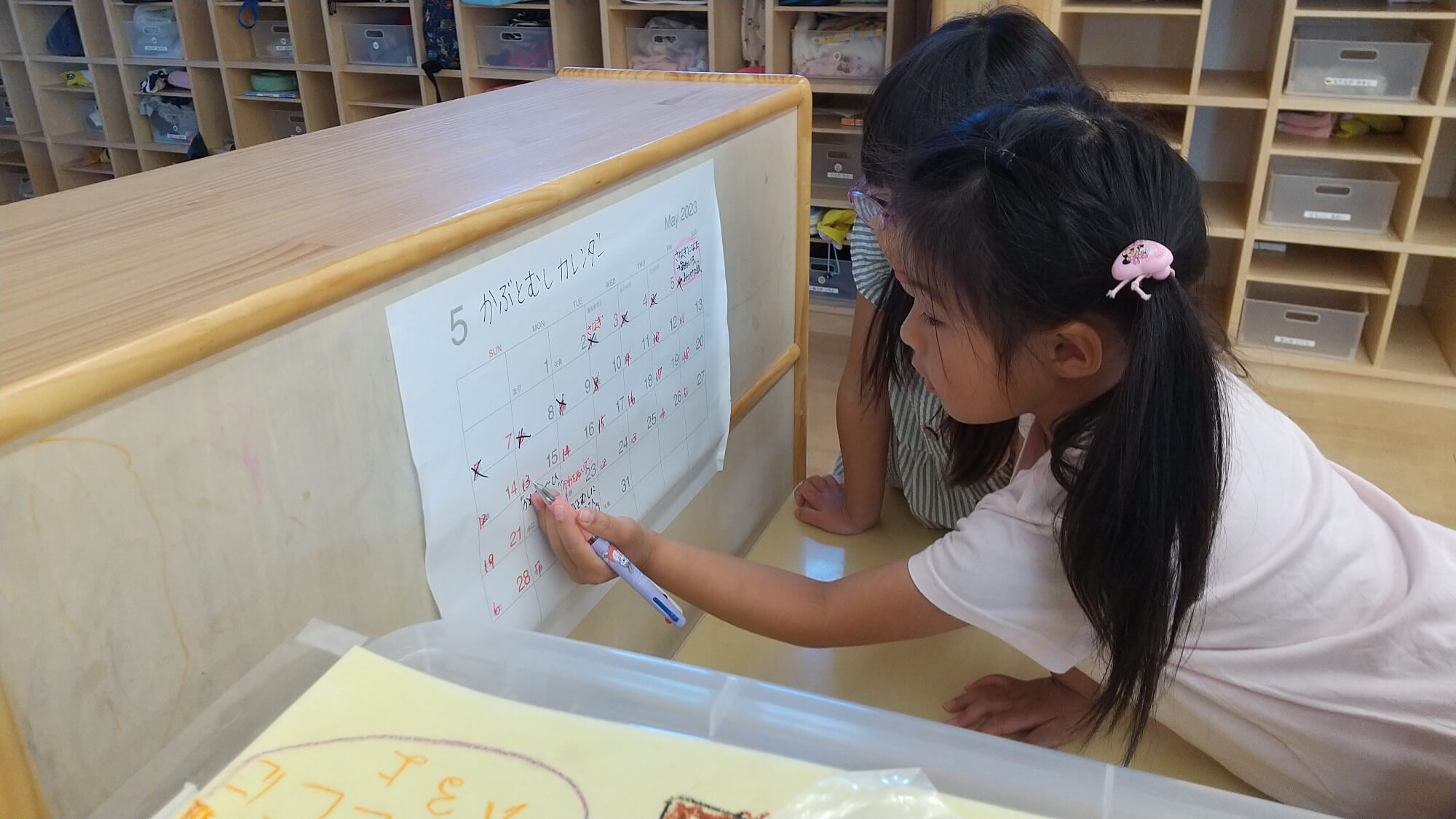カレンダーに記入をする子ども