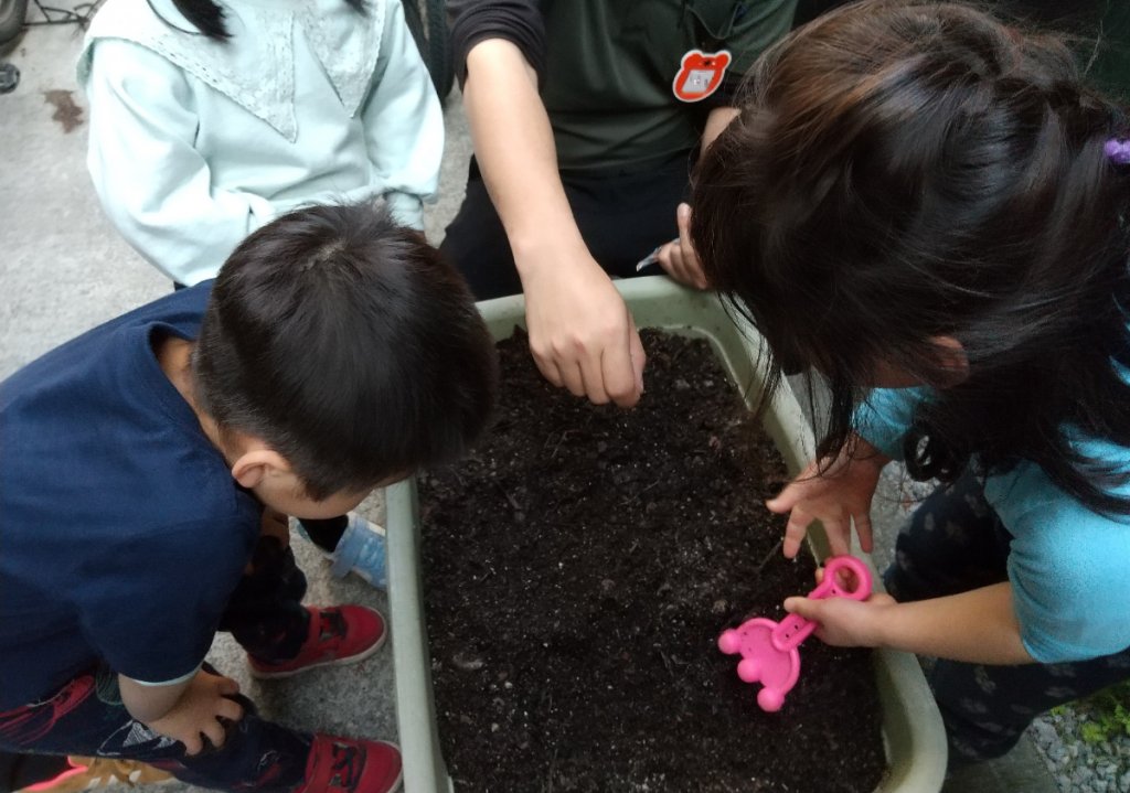 土に種をまく子どもたち