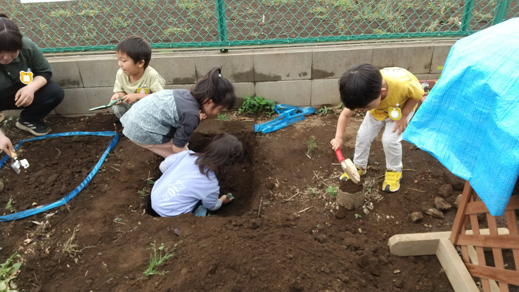 スコップで穴を掘る子どもたち