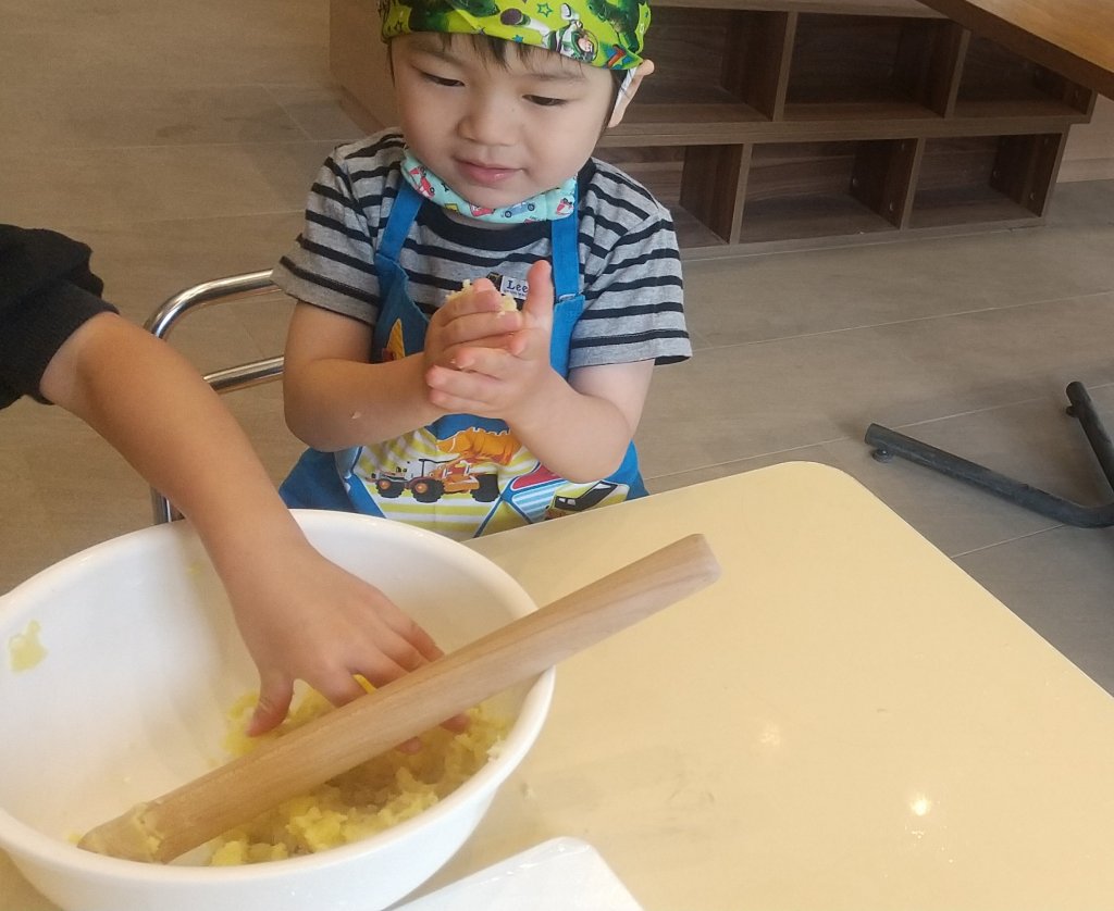 すりつぶしたじゃがいもを丸める子ども
