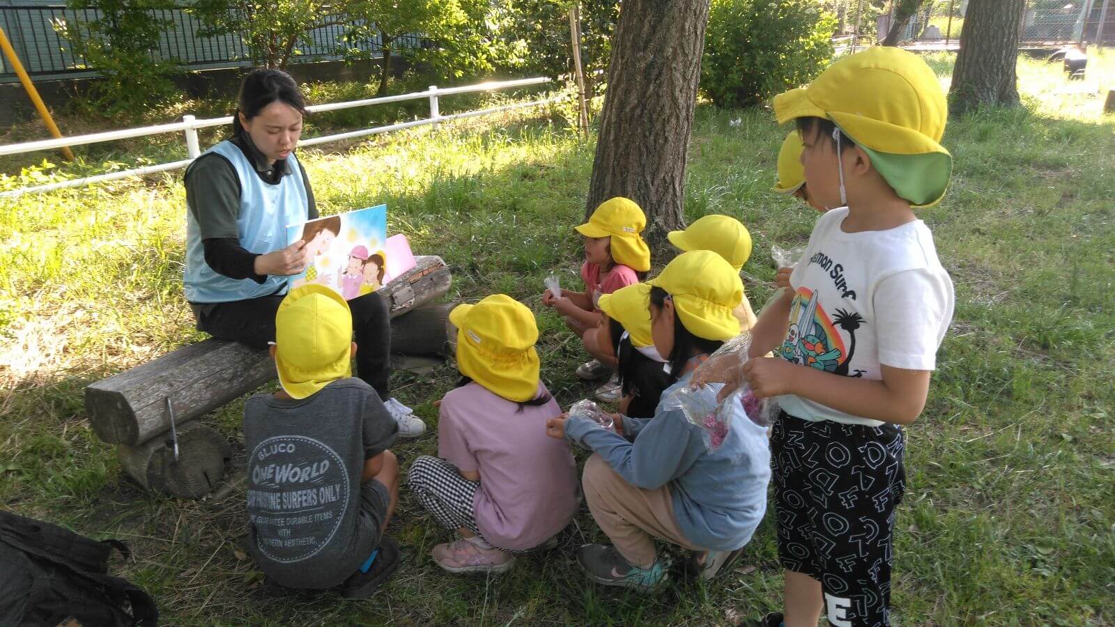 公園で絵本の読み聞かせをする様子