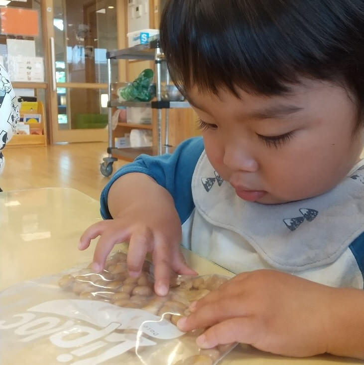 夢中で大豆を潰す子ども