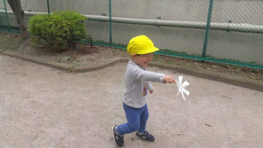 風車をもって走る子ども