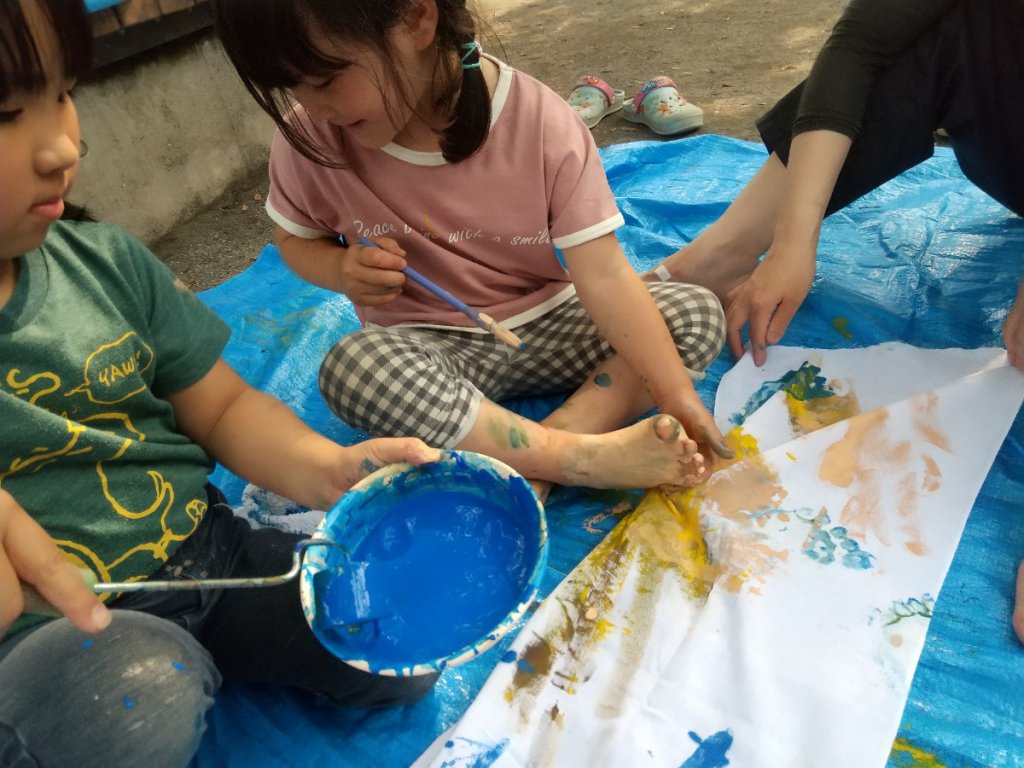 絵具で色を塗る子どもたち