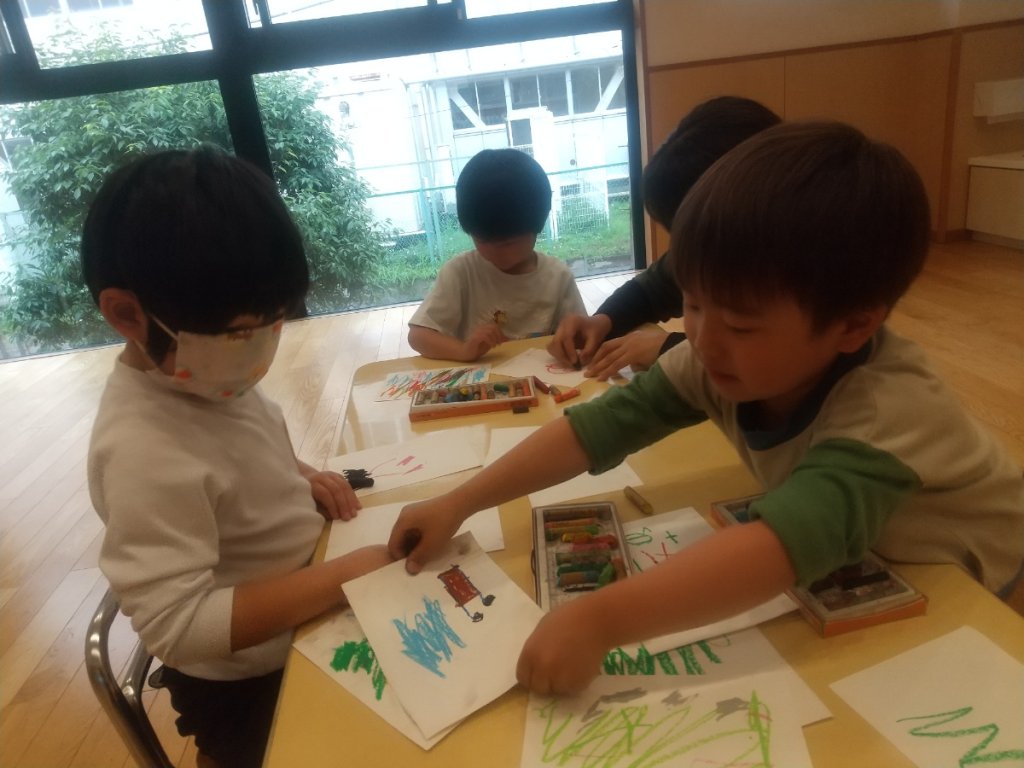 クレヨンでお絵描きする子どもたち