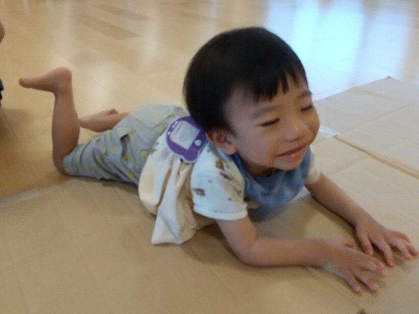 段ボールの上に乗って遊ぶ子ども