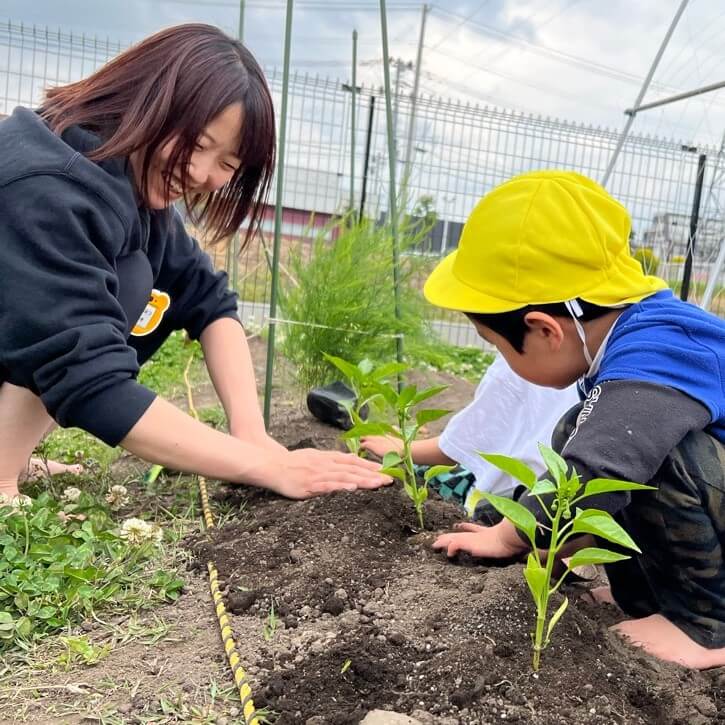 畑仕事をするスタッフと子どもたち