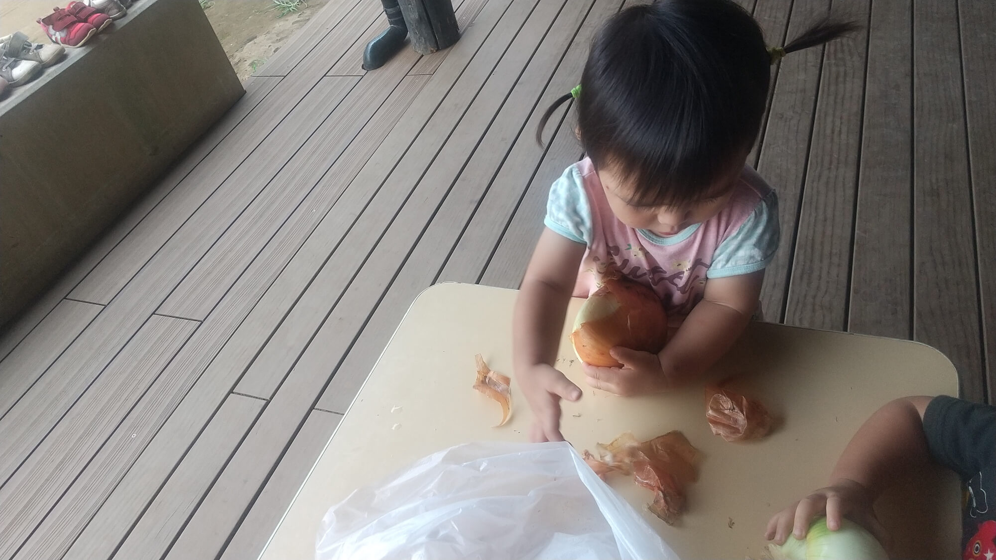 玉ねぎの皮むきをする子ども
