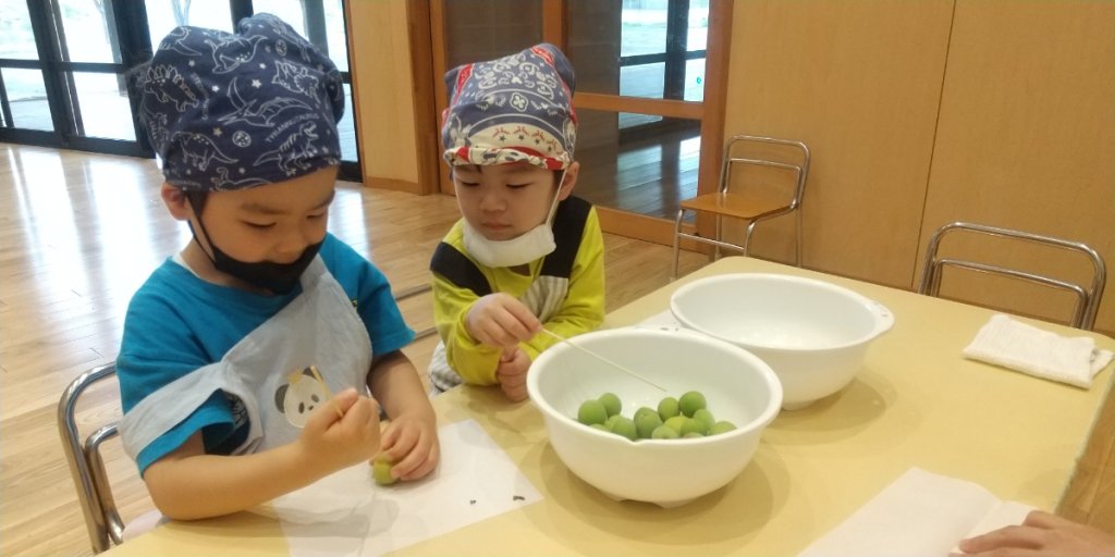 梅のヘタ取りをする子どもたち