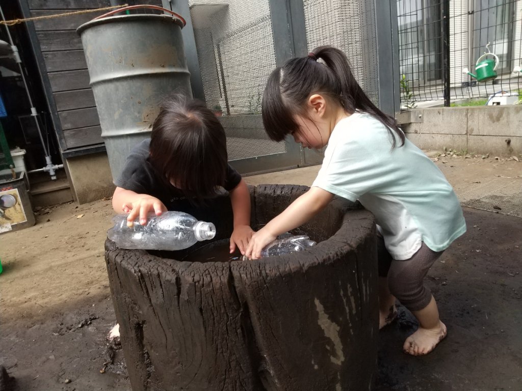 友達と水を入れて遊ぶ様子