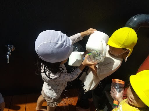 協力して水遊びをする子どもたち