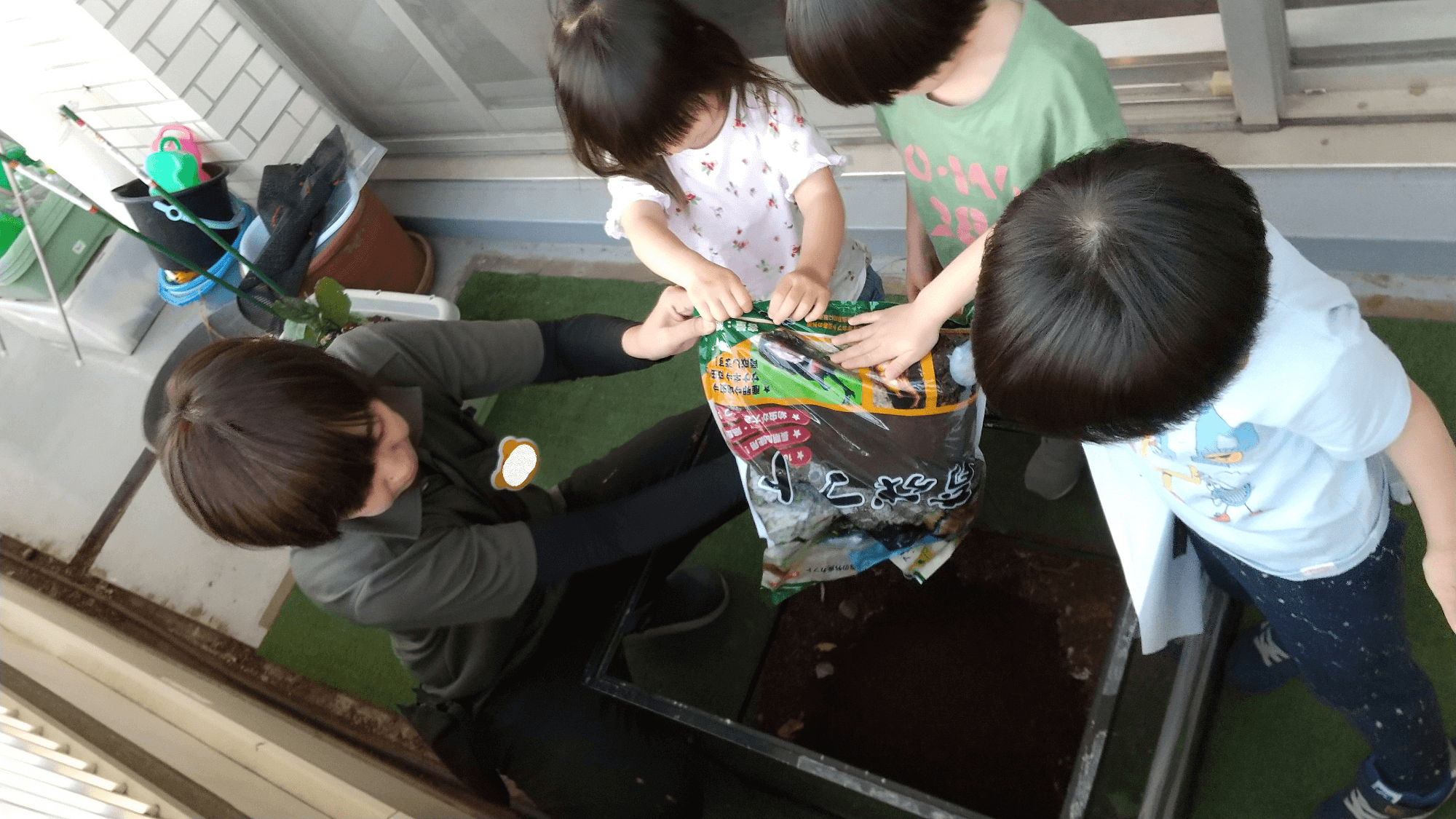 土を入れる子どもたち