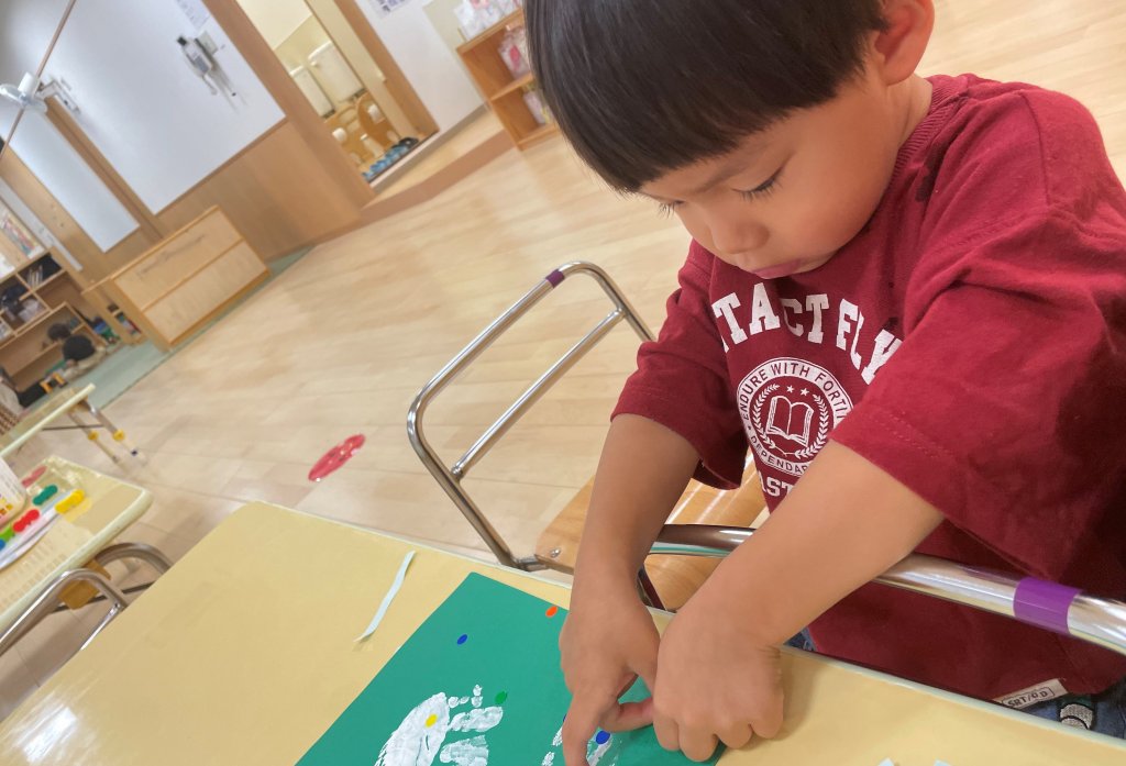 画用紙にシールをはる子どもたち