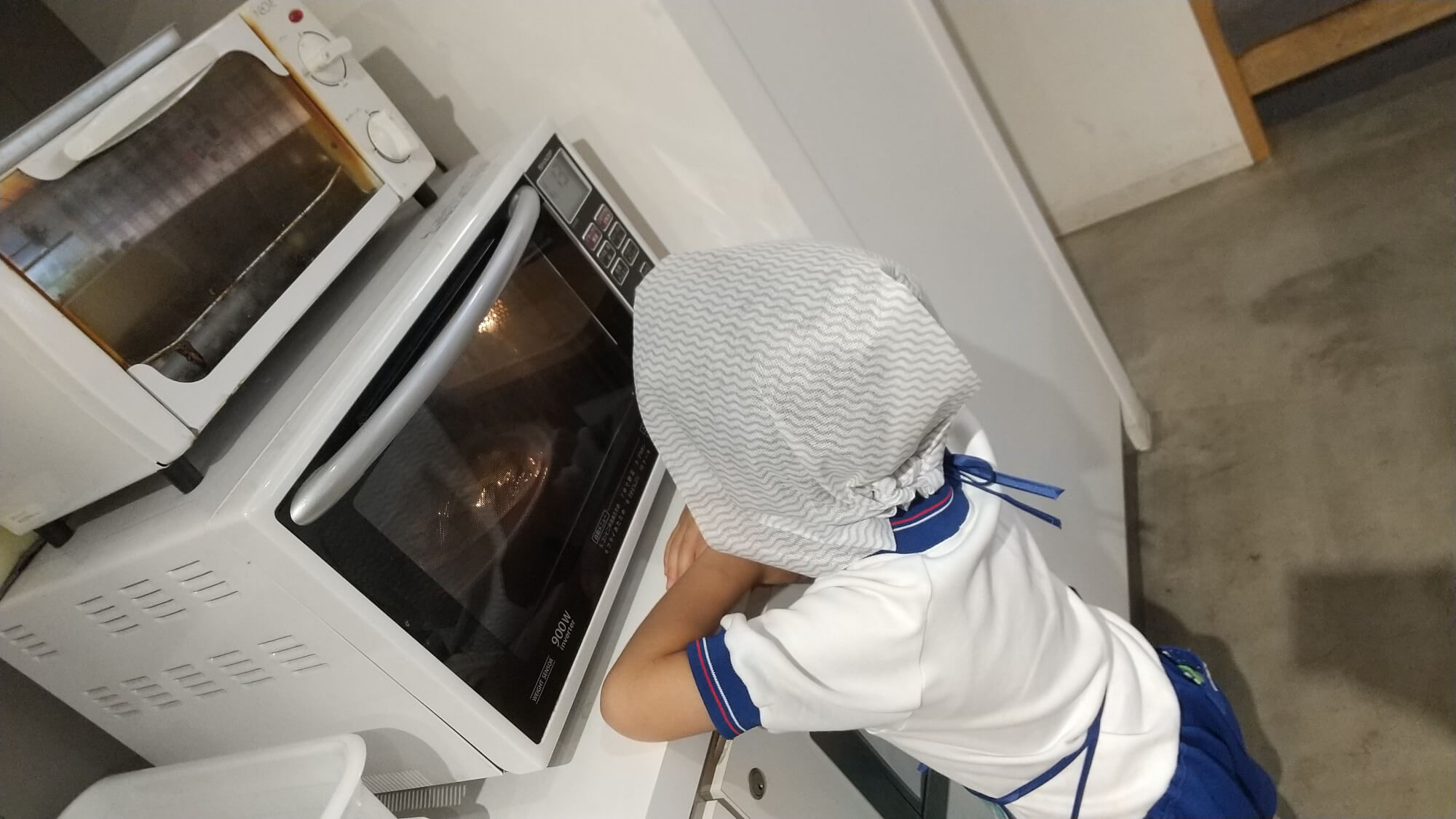 レンジで加熱される様子を眺める子ども