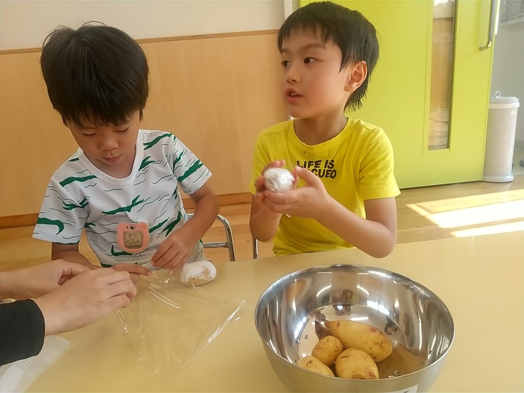 じゃがいもをラップで包む子どもたち
