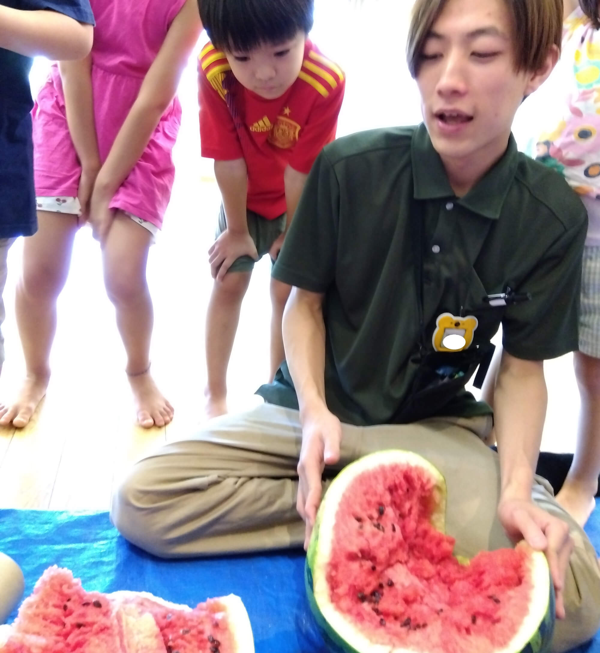 割れたスイカを見つめる子ども