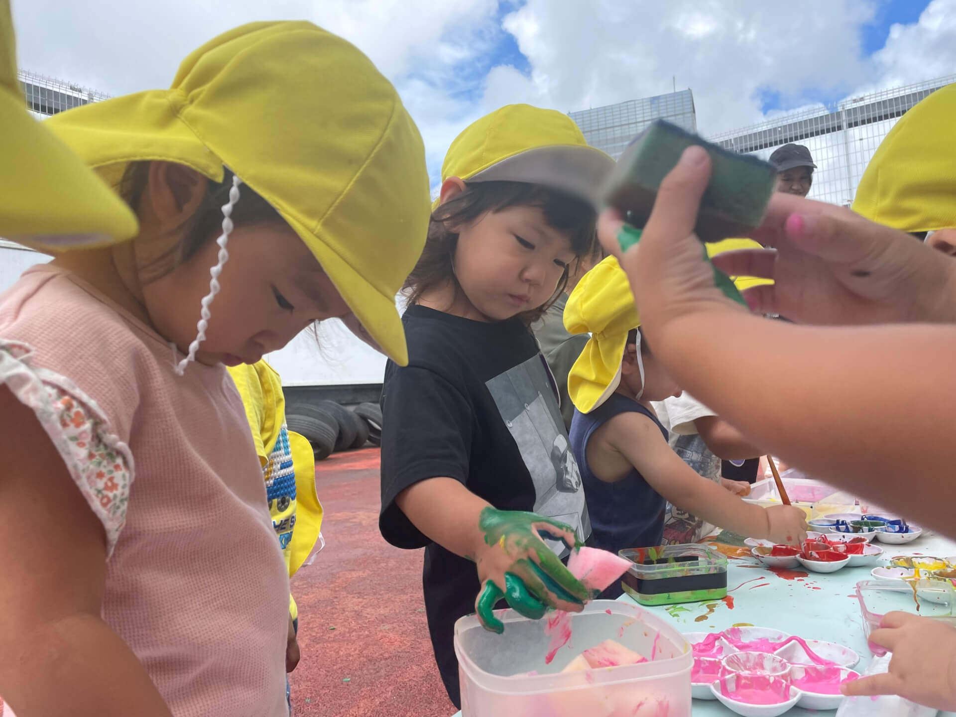 手が絵の具まみれの子どもたち