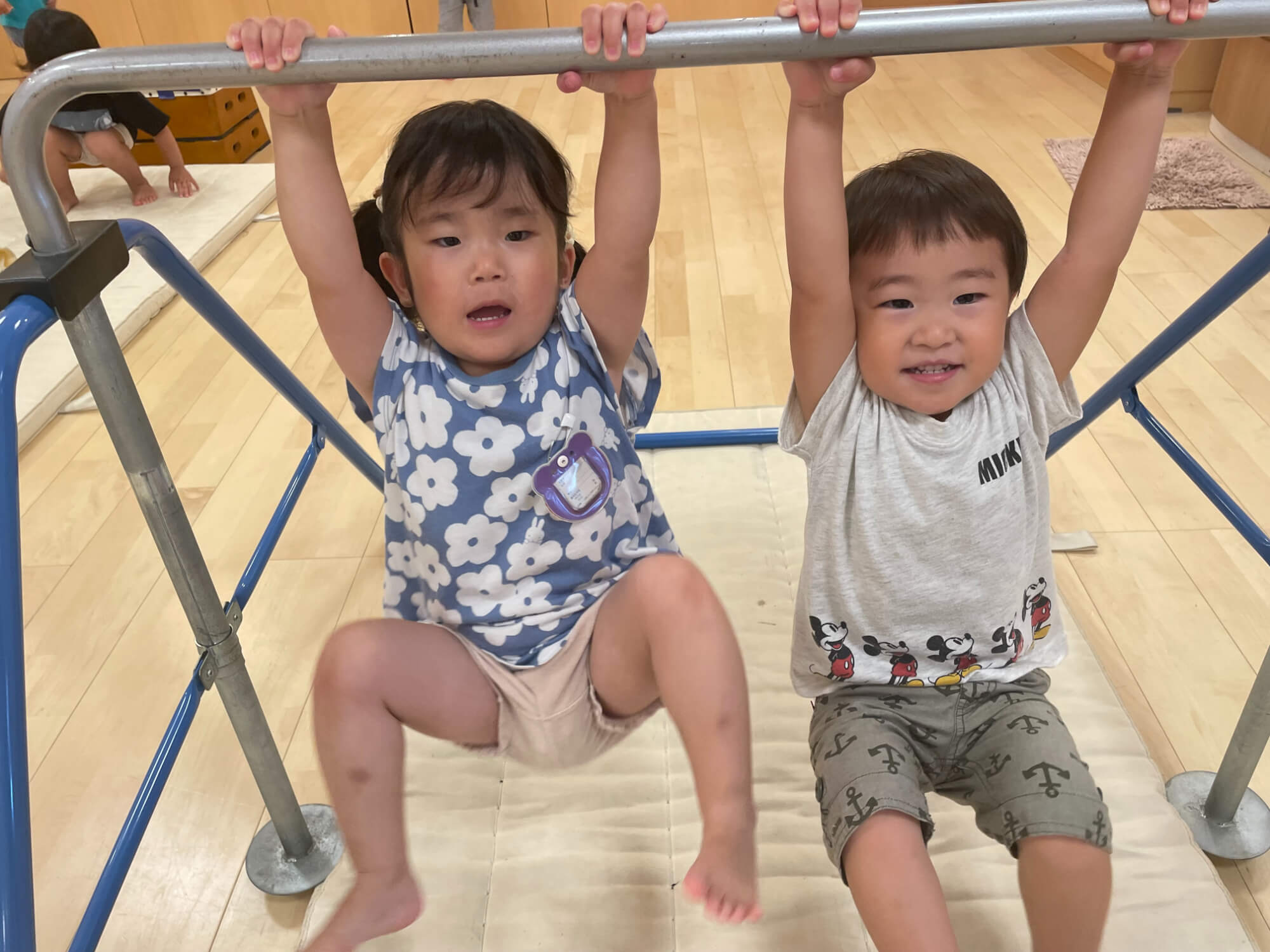 鉄棒にぶら下がる子どもたち