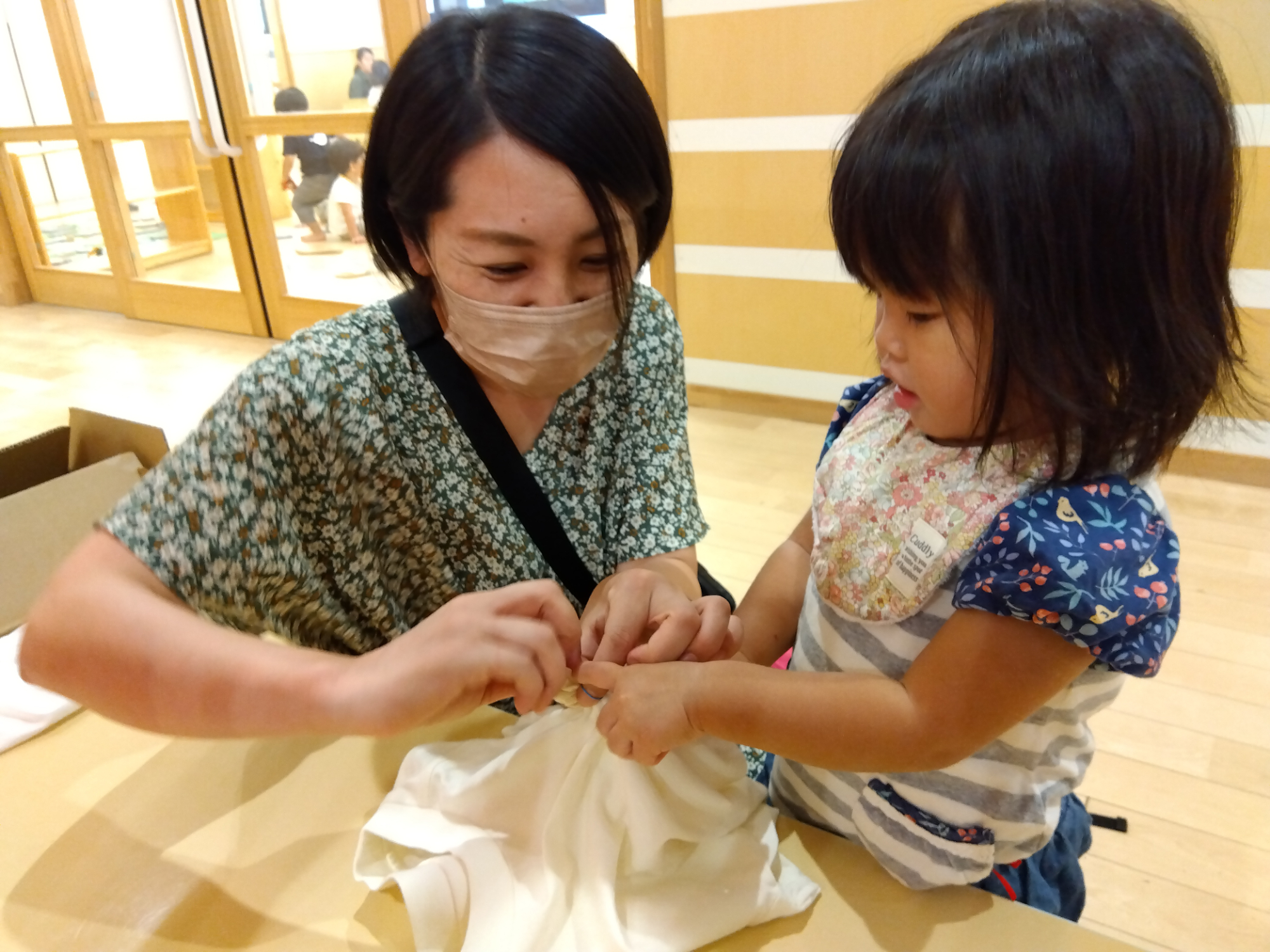 Tシャツを縛る子どもと保護者