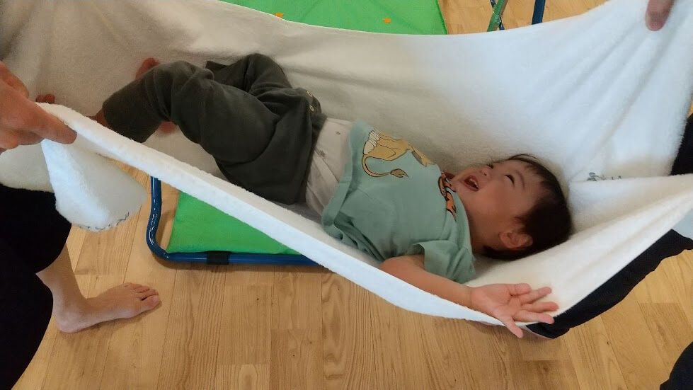 毛布にくるまれてゆらゆらする子ども