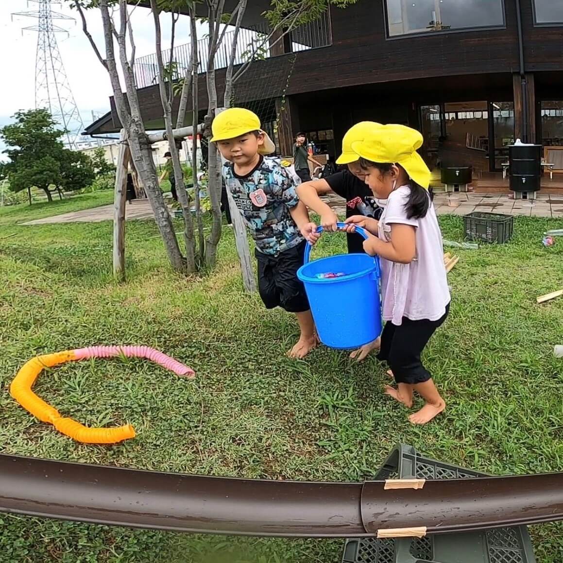 バケツを運ぶ三人の子どもたち