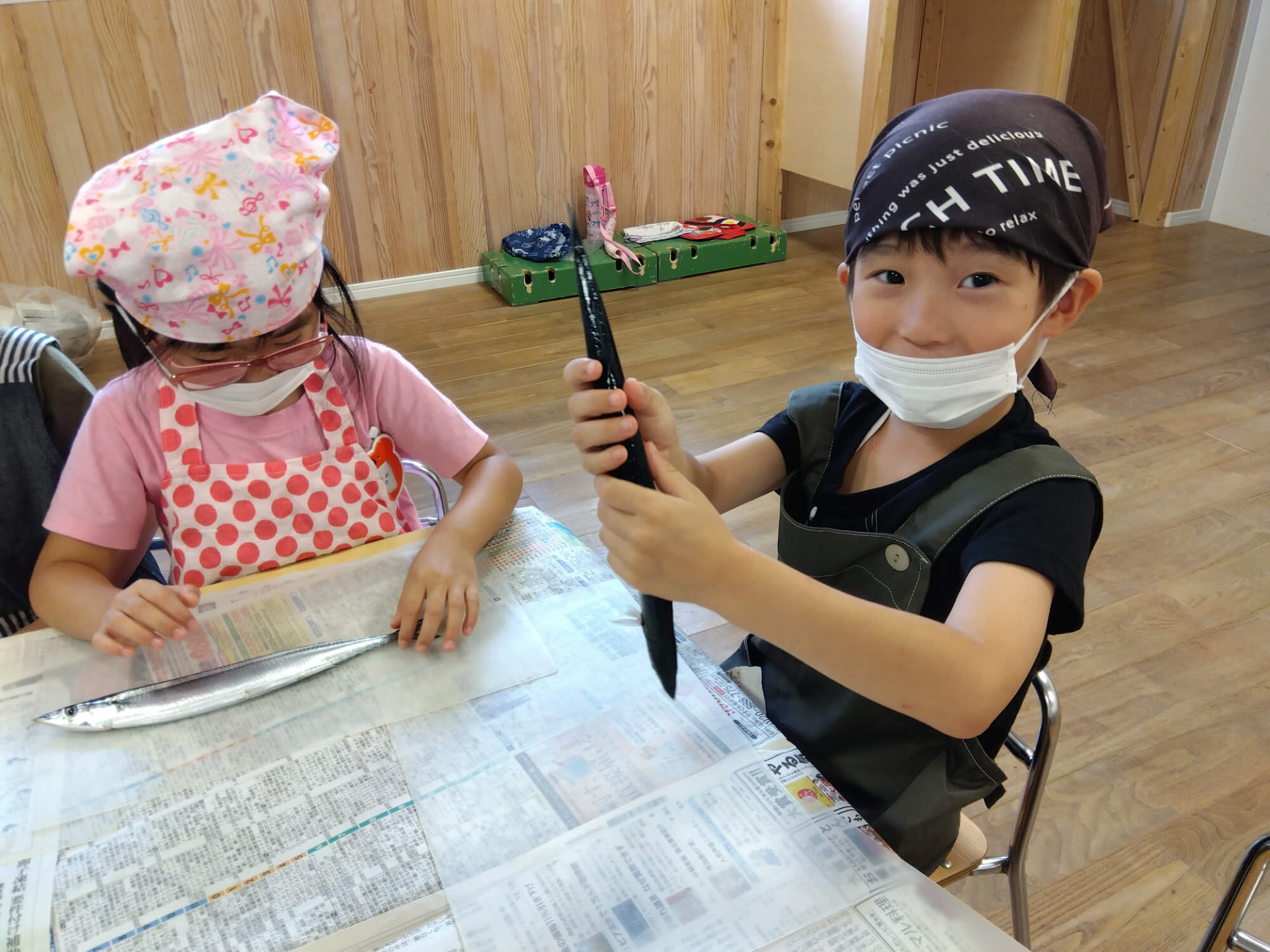 生のサンマを持つ子ども