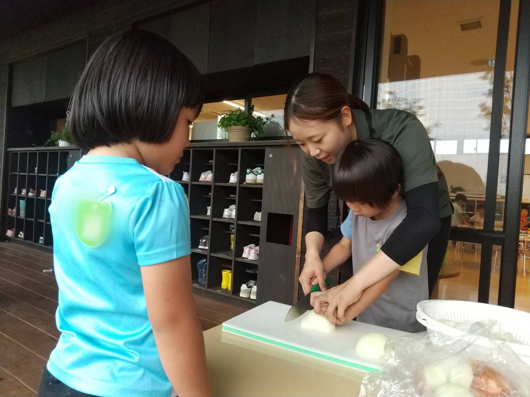 スタッフと野菜を切る子ども