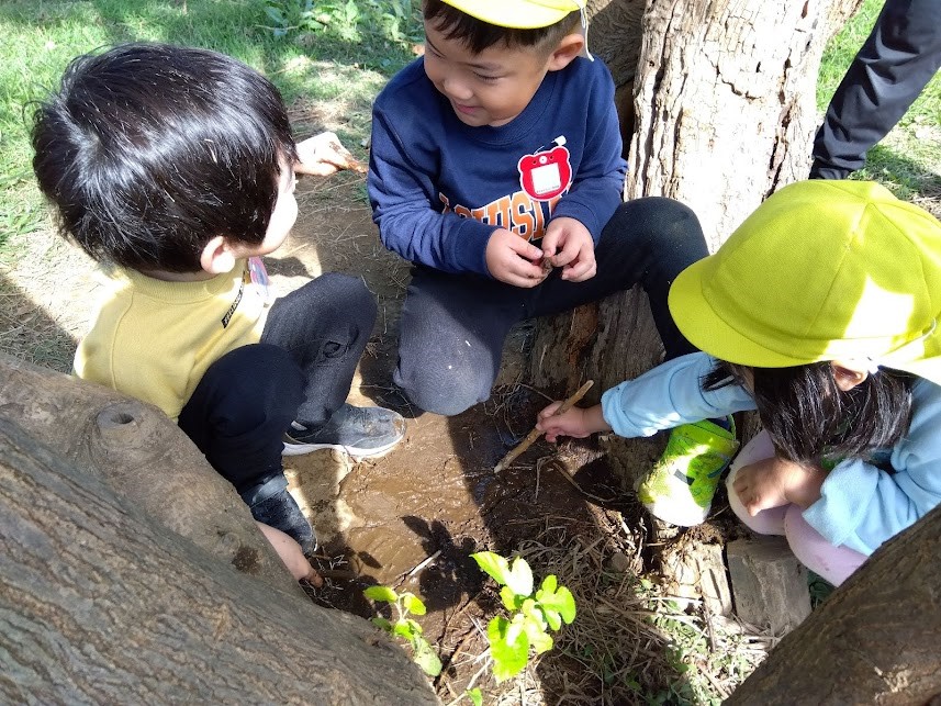 泥に手で触れる子どもたち