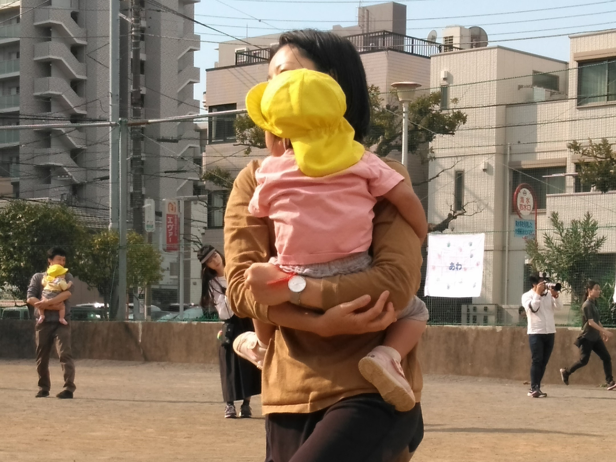 保護者に抱きかかえられる子ども