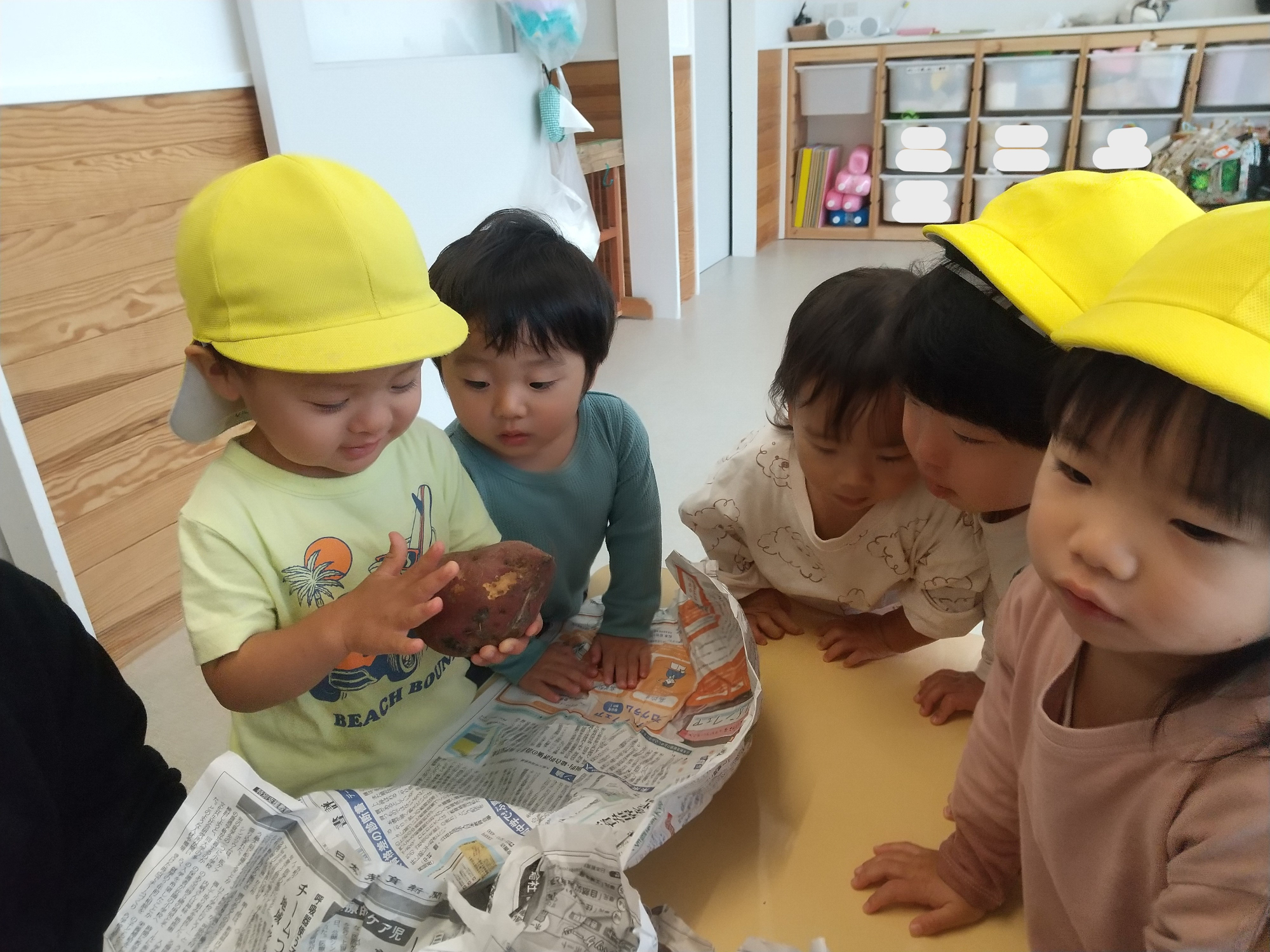 土のついたサツマイモを触る子ども