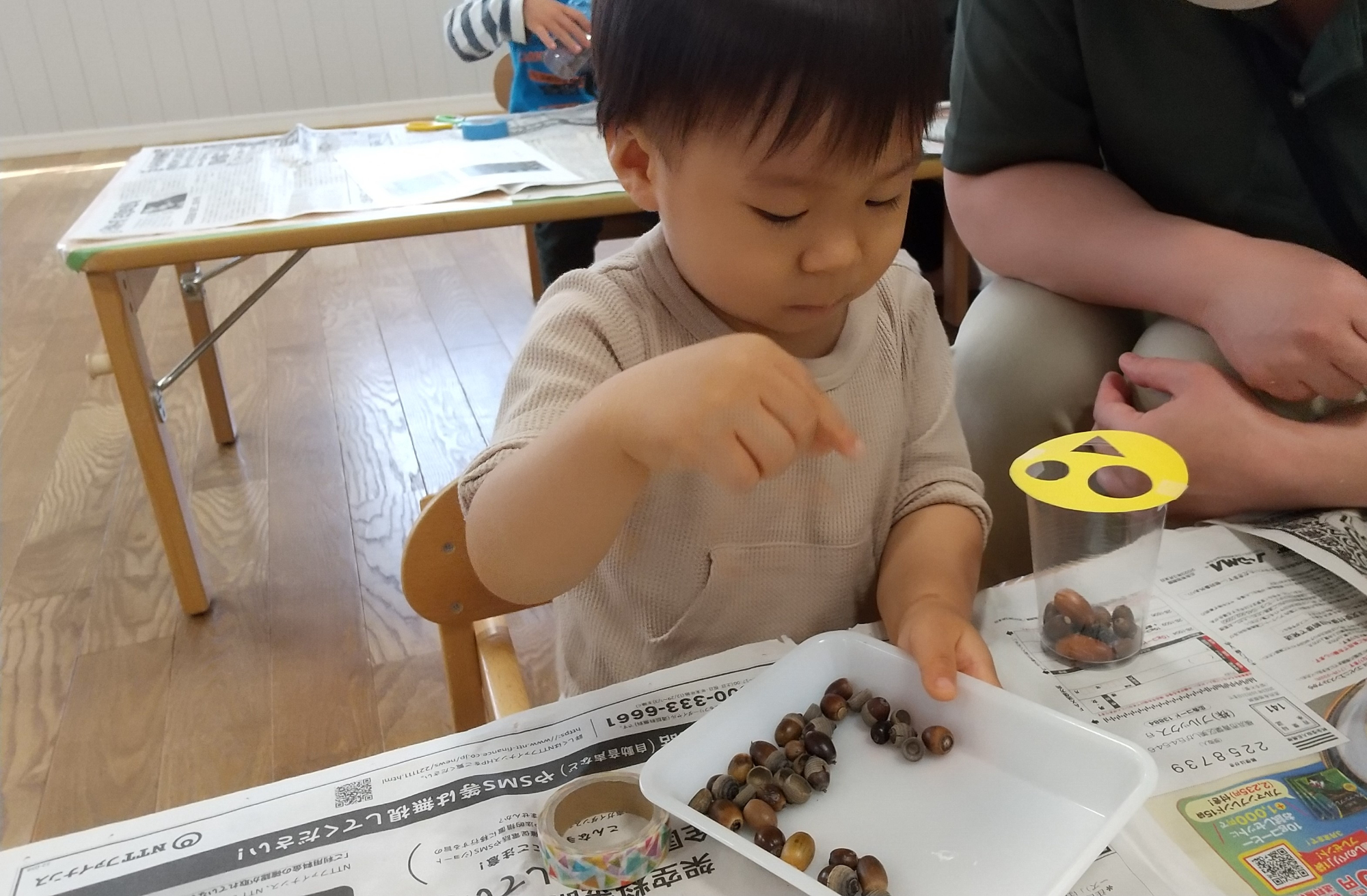 どんぐりをつまんでいく子ども