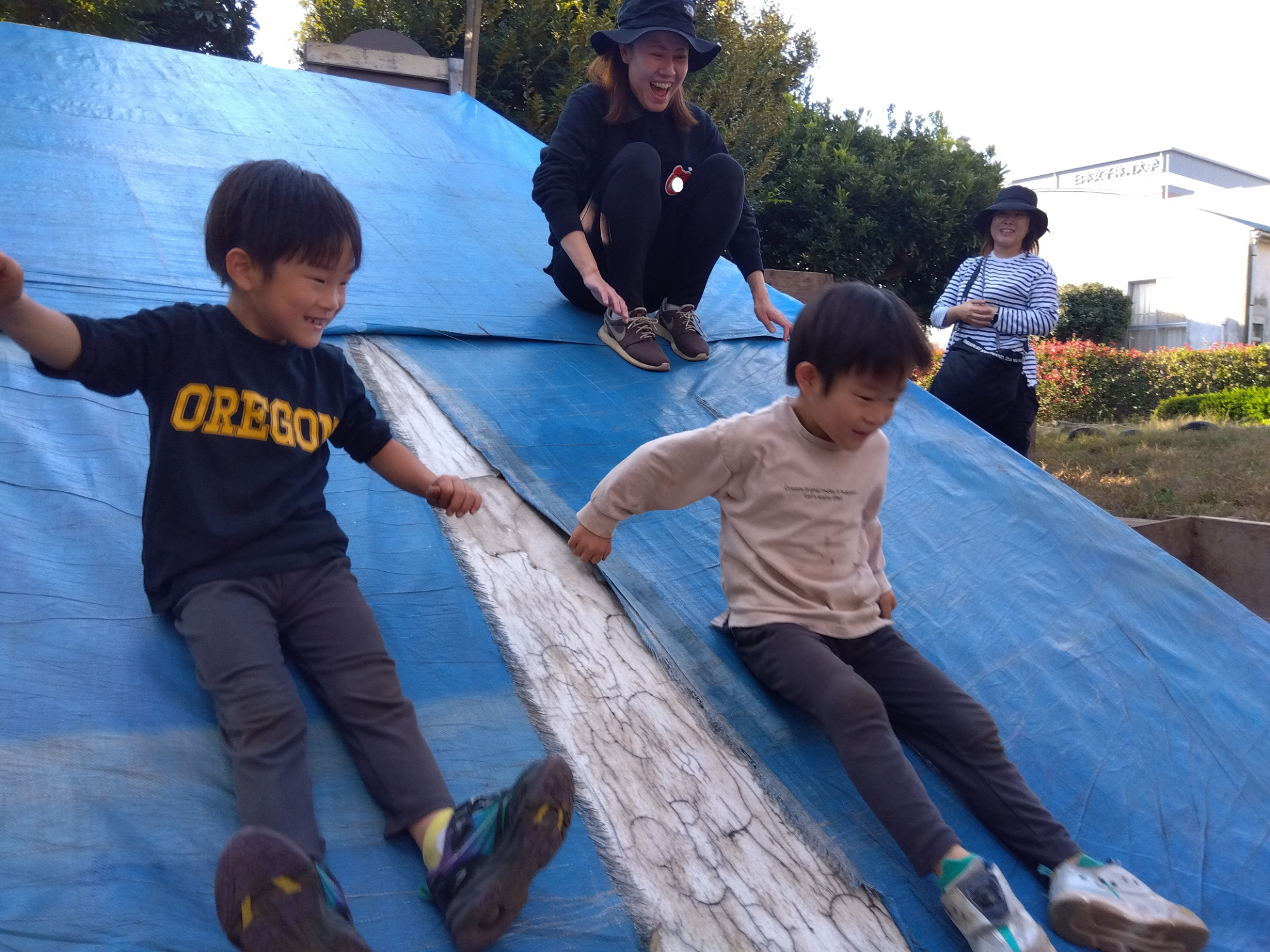 斜面を滑り降りる子どもたち