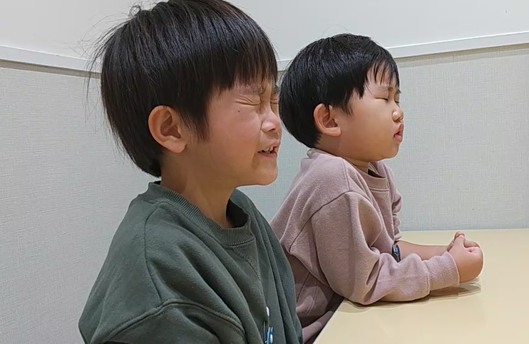 強く目をつむる子どもたち