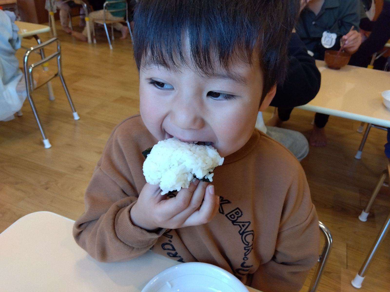おにぎりを頬張る子ども