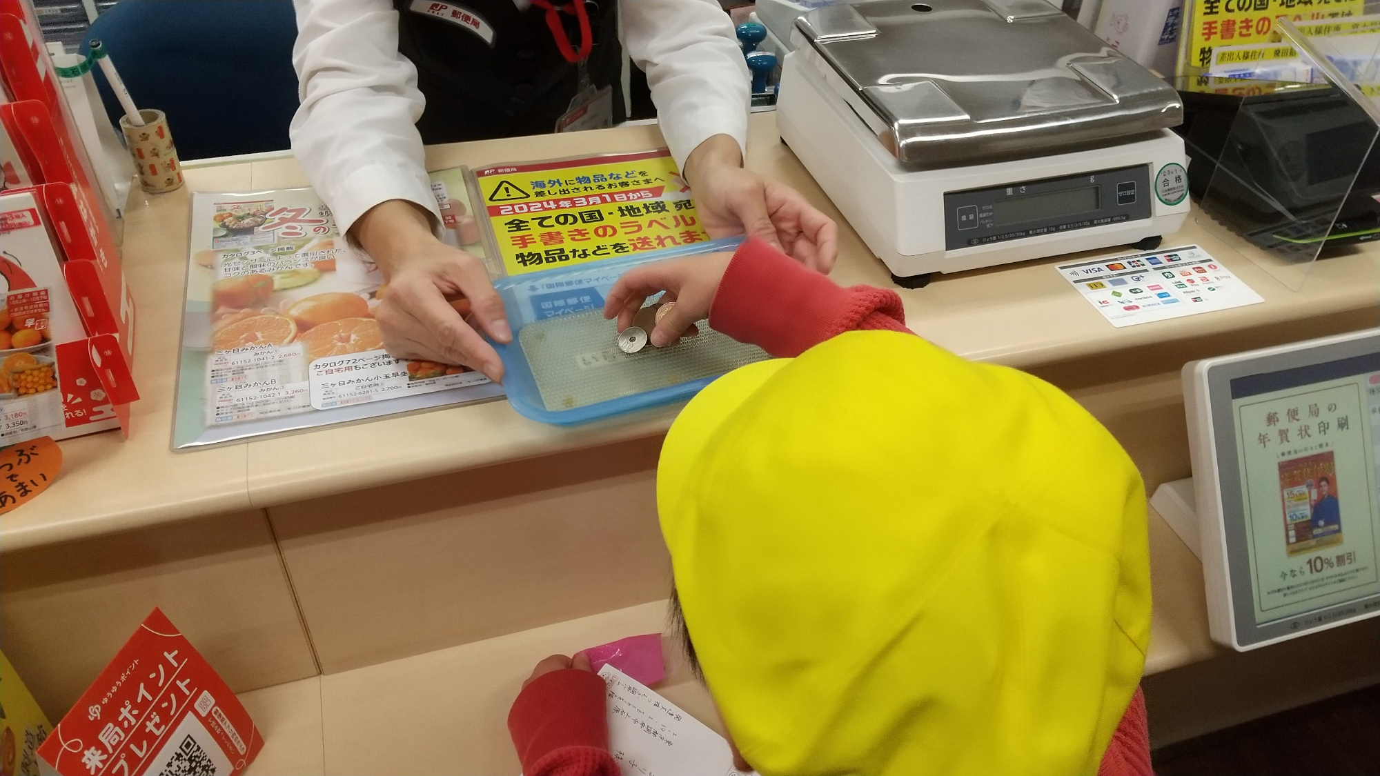郵便局で切手を購入する子ども