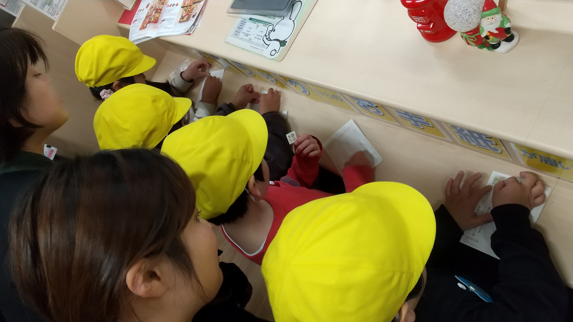 はがきに切手を貼る子どもたち