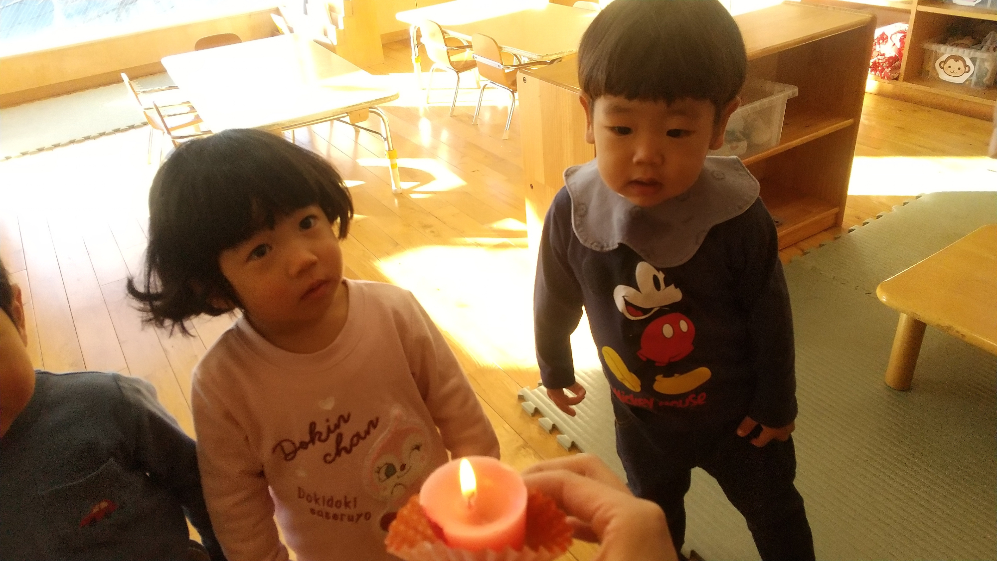 キャンドルの火に近づく子どもたち