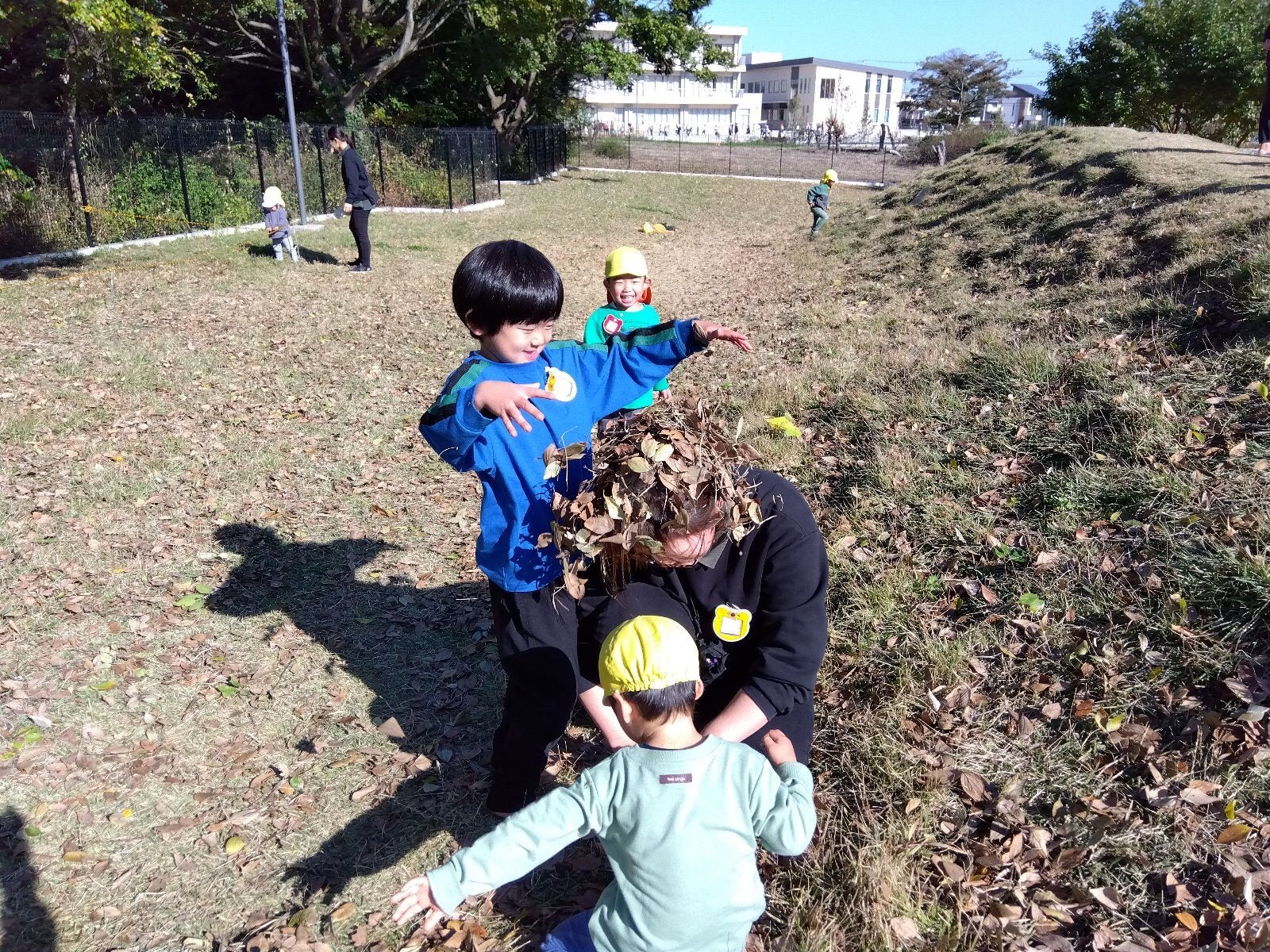 落ち葉で遊ぶ子どもたち