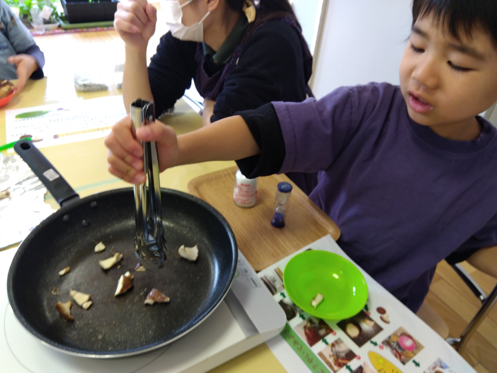焼けたしいたけを皿に取る子ども