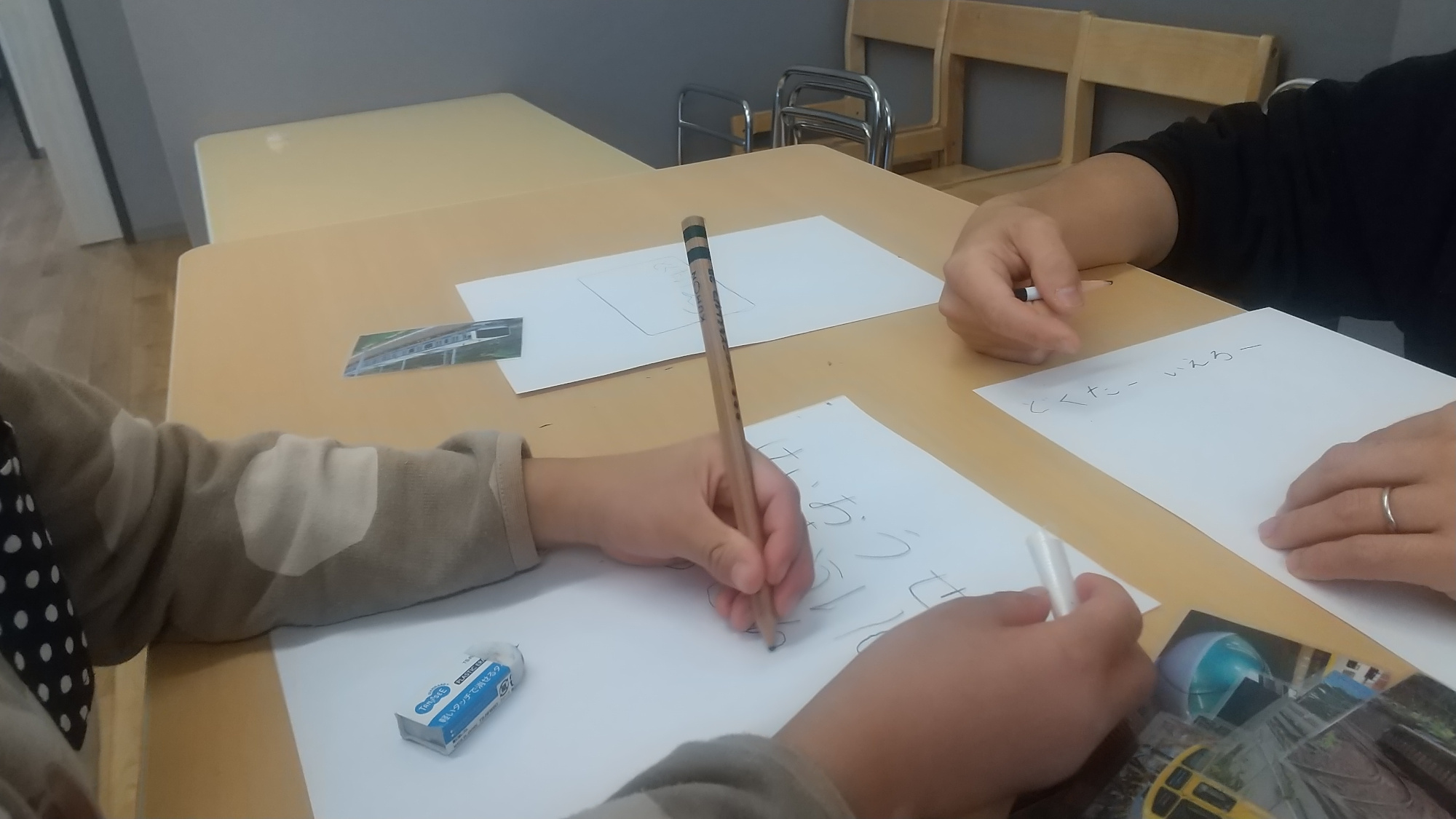 紙に電車の名前を書く子どもたち