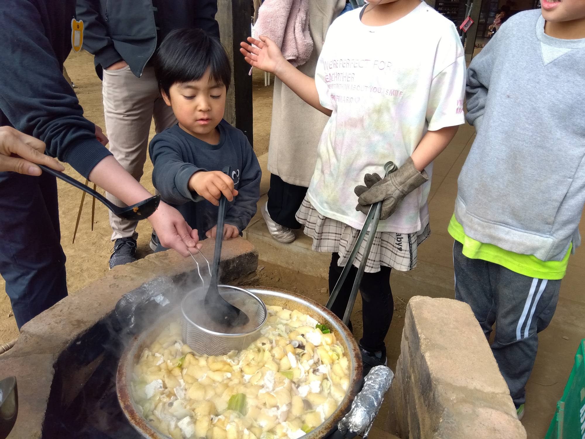 かまどで味噌汁を作る様子