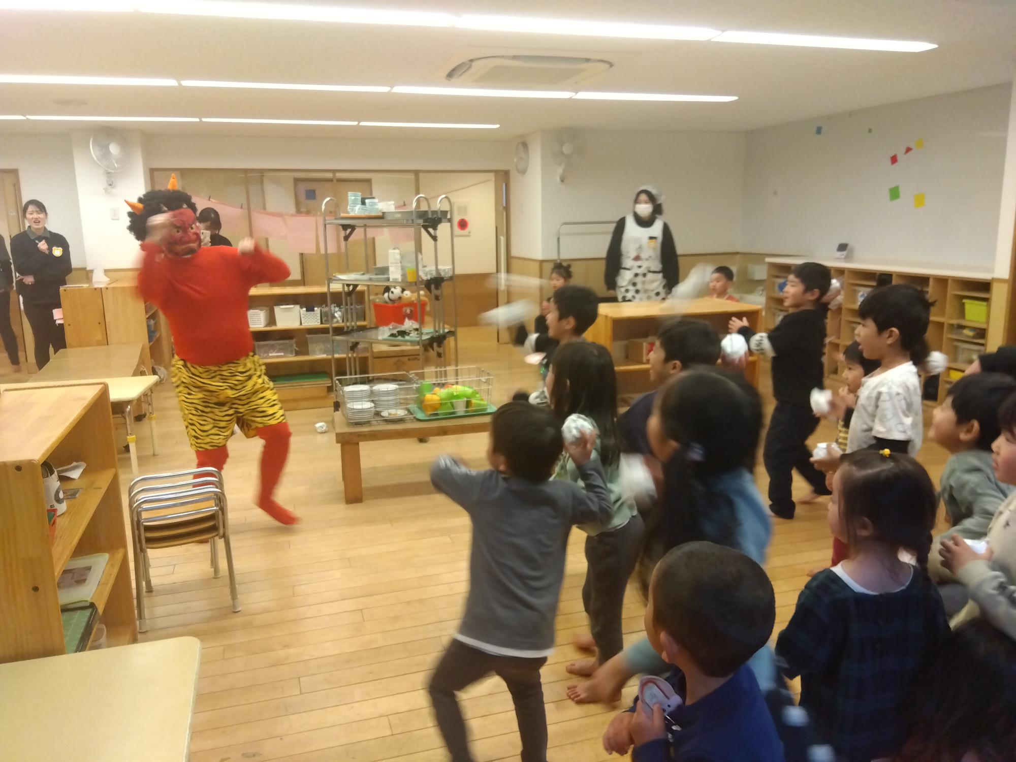 室内で豆まきを行う子どもたち