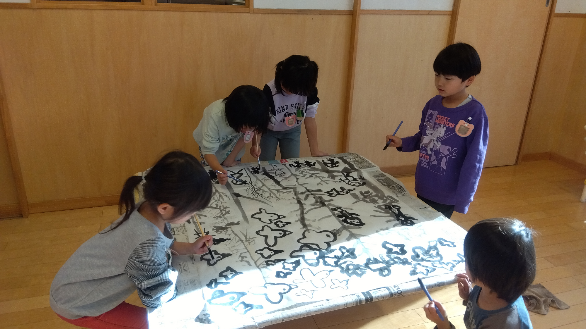 筆で絵を描く子どもたち