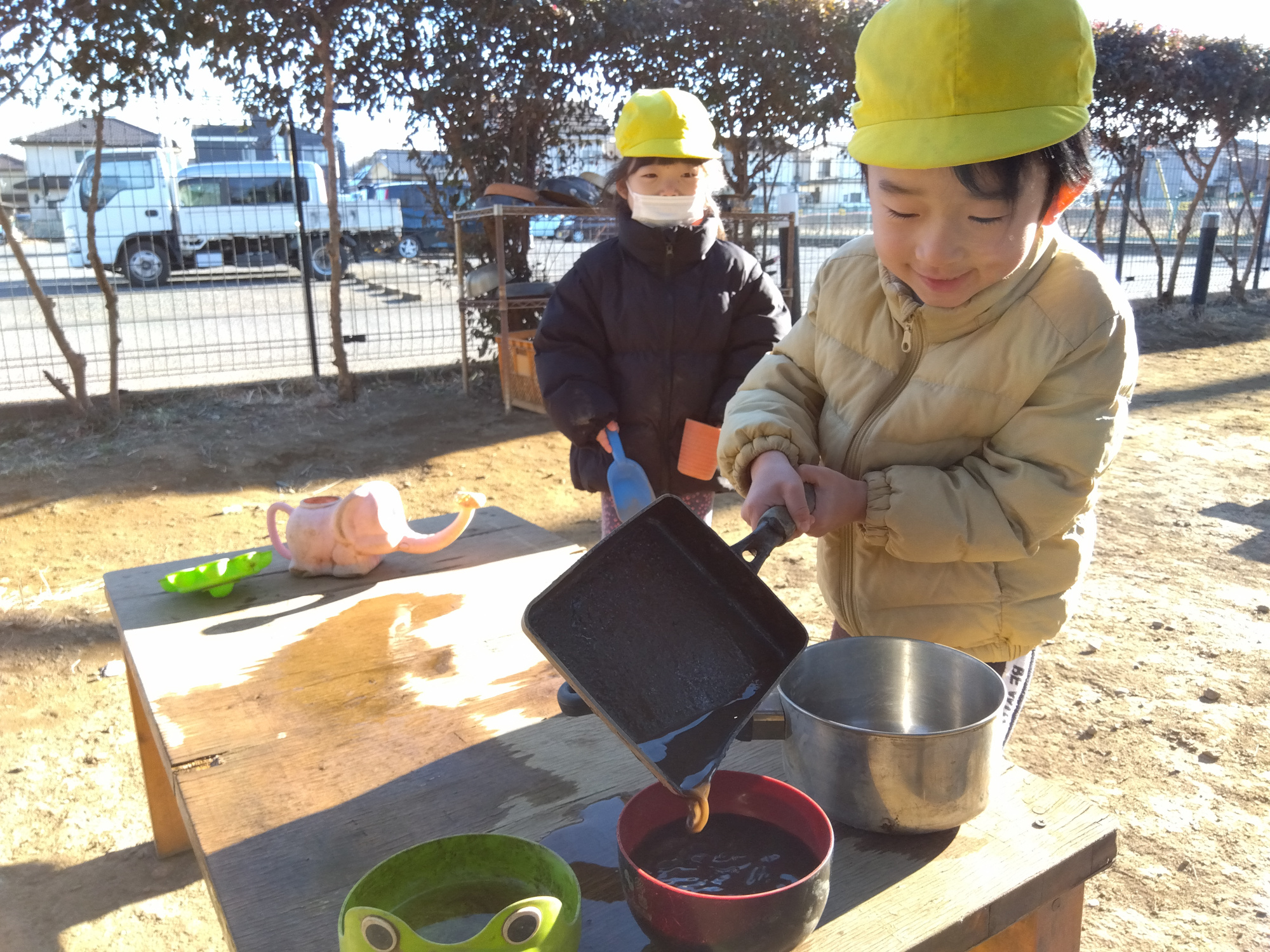 園庭でおままごとをする子どもたち