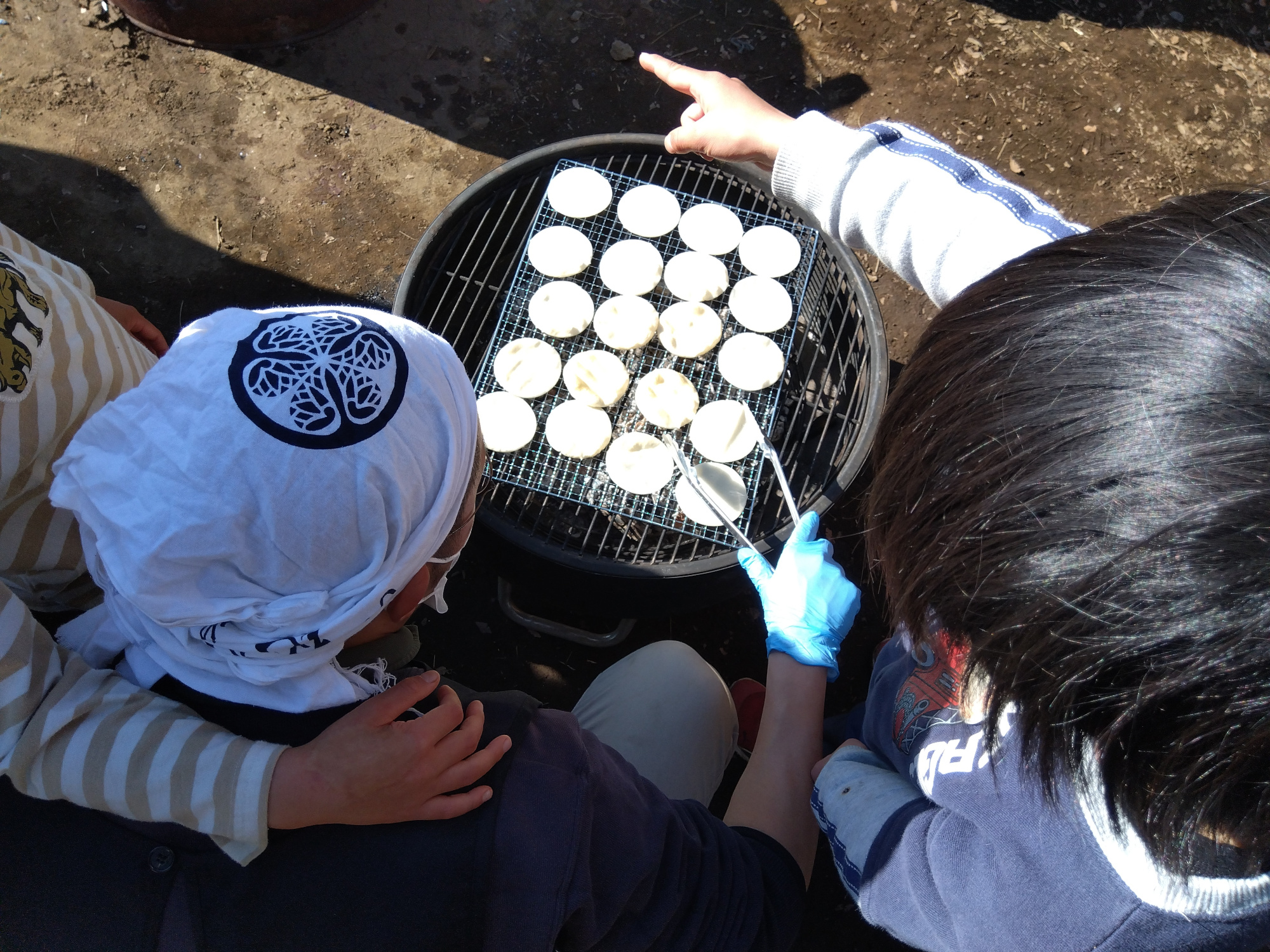 焼けるせんべいを見守る子どもたち