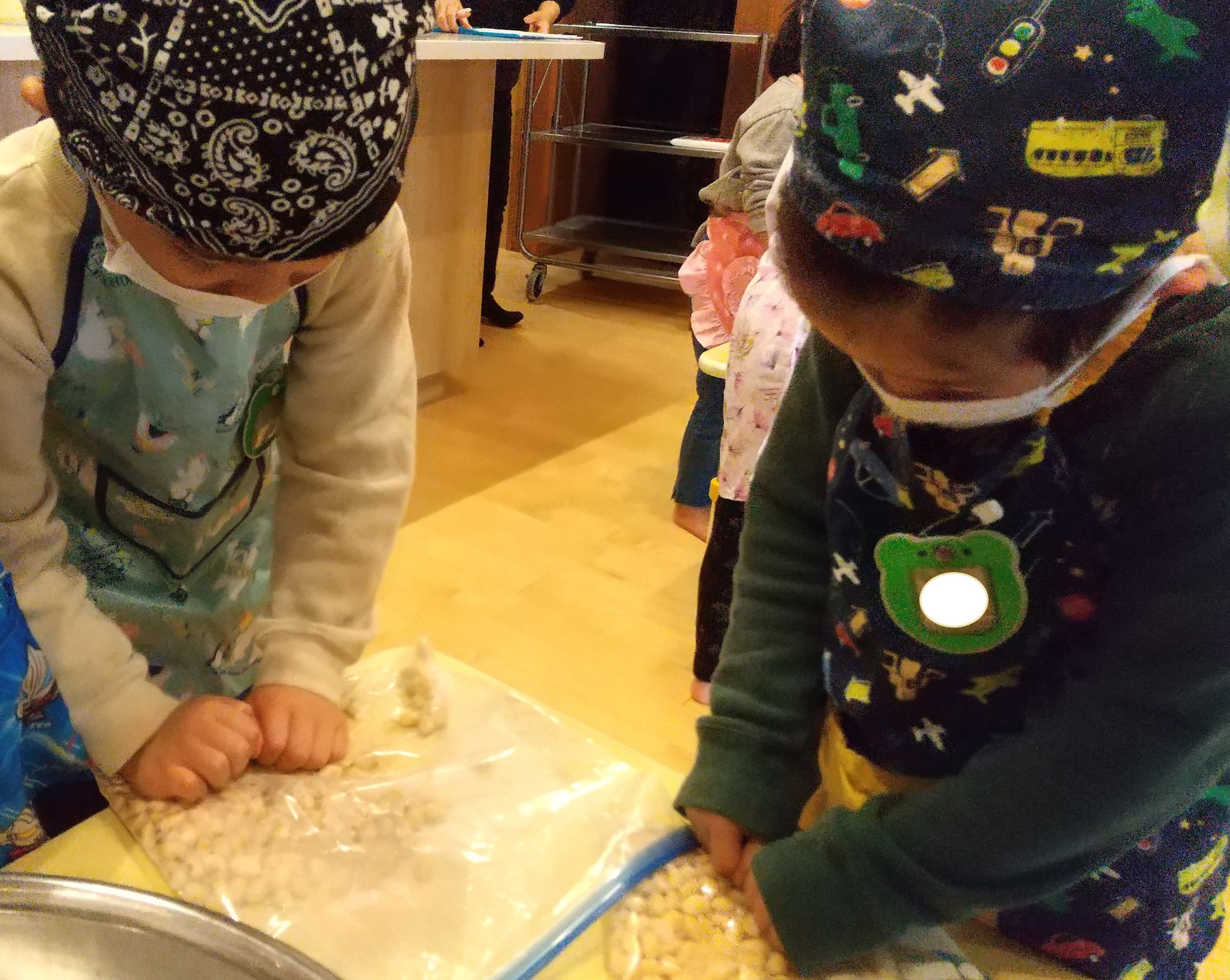 ポリ袋の上から大豆を潰す子どもたち
