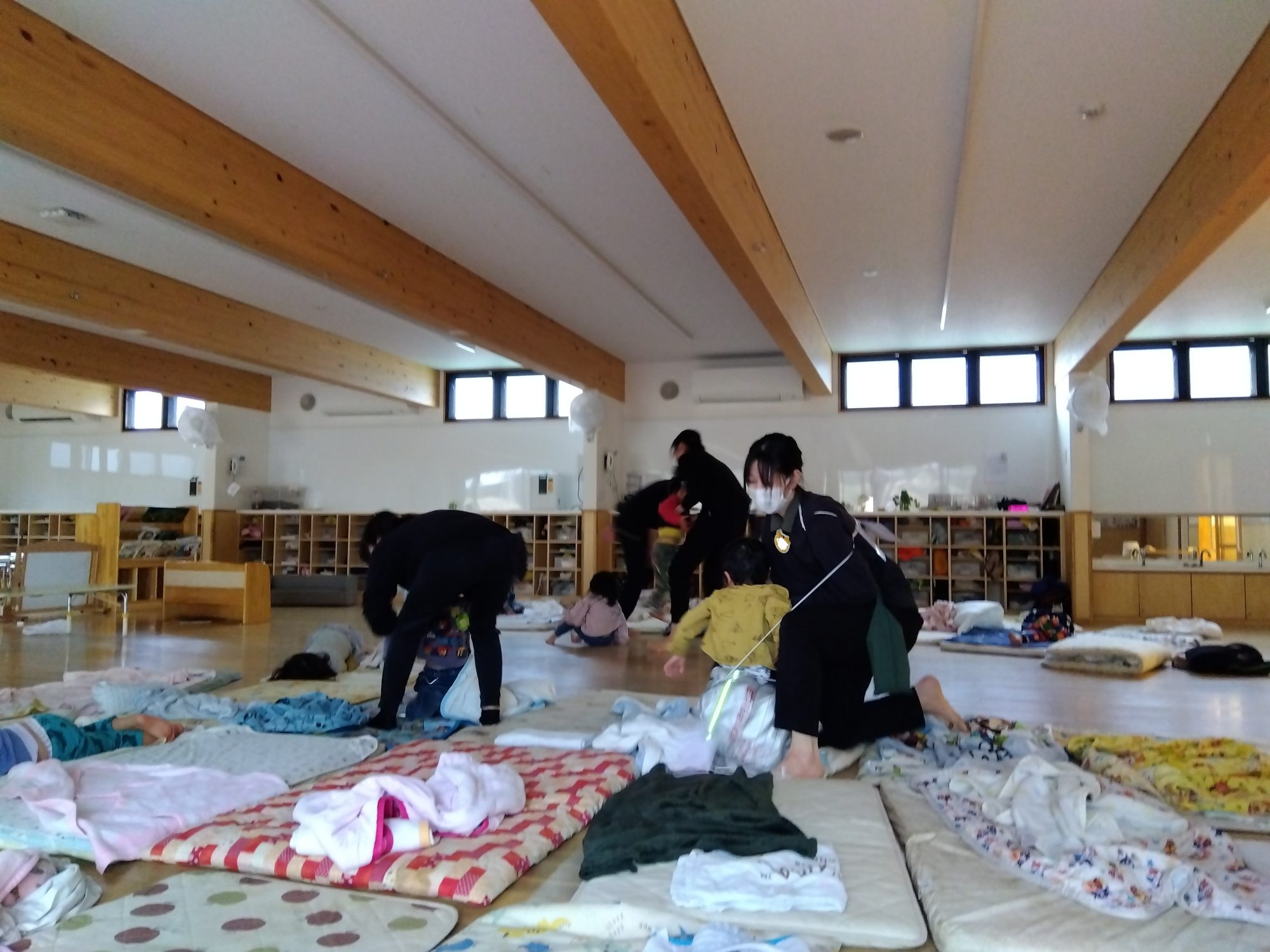 午睡中の子どもたちを起こし、避難を促すスタッフたち