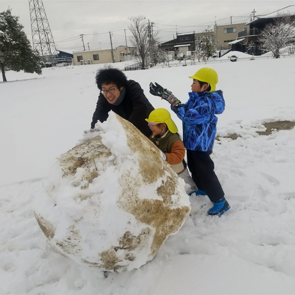 雪だるまをおす保育士